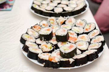 Plate full of appetizing California rolls, a tasty japanese culinary tradition being served
