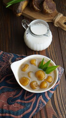 Indonesian traditional food. Selective focus, kolak biji salak on wooden background.