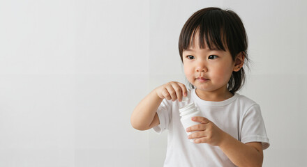 Young Asian girl playing with toy ice cream in white shirt indoors  