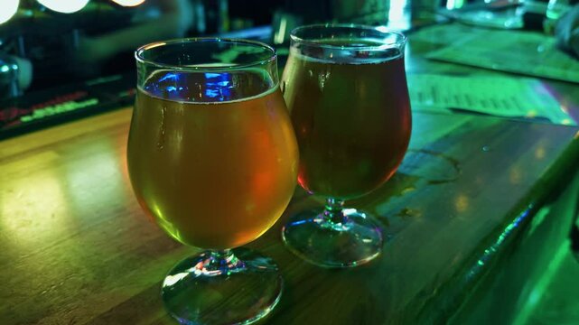Cinematic shot capturing chilled beers on shiny surface with neon ambiance and condensation