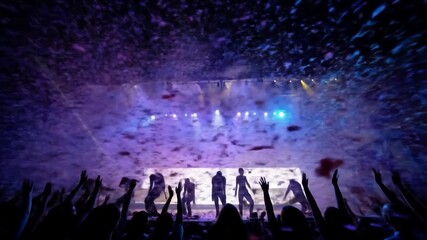 A concert scene with silhouettes of performers on stage, hands raised, amidst falling confetti under a purple lit sky. The crowd is in the foreground