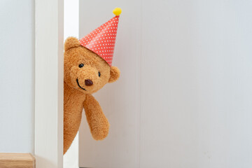 Teddy bear playing hide and seek behind the sofa, Adorable child having fun in the home. happy...