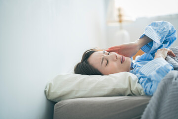 体調不良で寝込んでいる女性