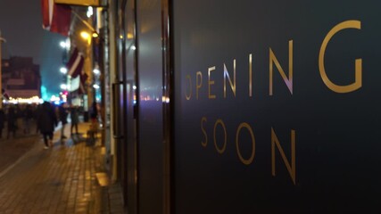 Evening street scene, Nighttime pedestrian area ambiance with promotional signage and lively crowd