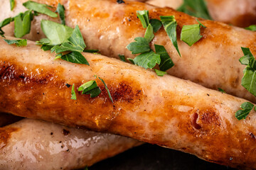 Ultra closeup of juicy grilled sausages with herbs