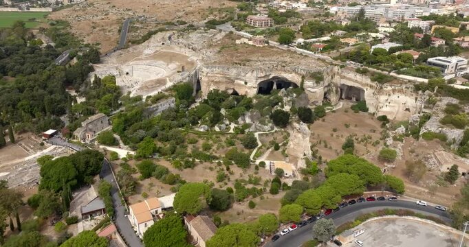 Aerial view of the Neapolis Archaeological Park, located in Syracuse, Sicily, Italy. In background are the ruins of the Greek theater, the Ear of Dionysius, the Ropemakers' and the Saltpetre Cave.