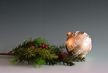 Weihnachtskugel und Tannenbaumzweig auf dem Hintergrund