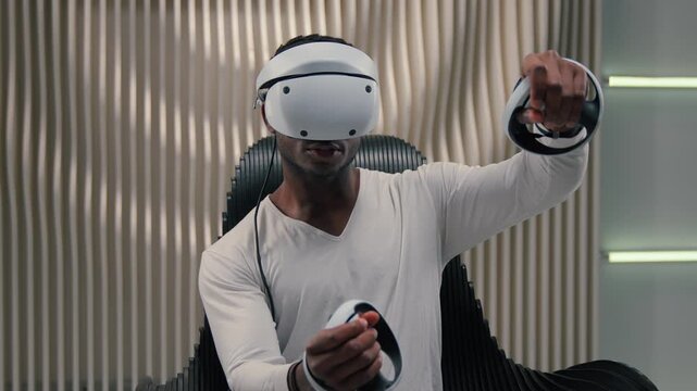 African American man in VR helmet holding controllers using virtual reality in futuristic space metaverse technology gamer guy male playing game driving car futurism innovation simulation interface