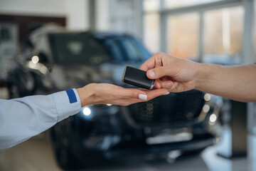 Ownership conception. Close up view of woman's and man's hands that are taking the keys for new car