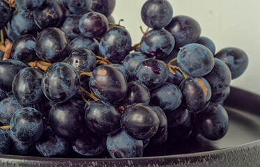 Extreme Close-up of Fresh Dark Blue Grapes on a Black Platter