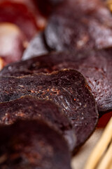 Dark dried meat slices macro textured closeup