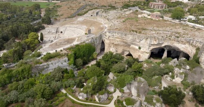 Aerial view of the Neapolis Archaeological Park, located in Syracuse, Sicily, Italy. Zoom on the ruins of the Greek theatre, Ear of Dionysius and the Grotta dei Cordari.