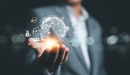 A business professional holding a glowing digital globe with financial, cloud, network, and data icons, representing global business, digital transformation, worldwide connectivity, analytics, modern