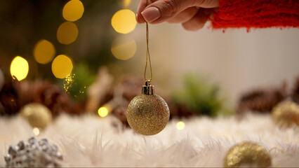 Hand Holding Glittery Christmas Ornament with Bokeh Lights