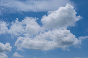 A soft, fluffy white cloud floating against a clear blue sky, creating a calm and minimal natural scene.