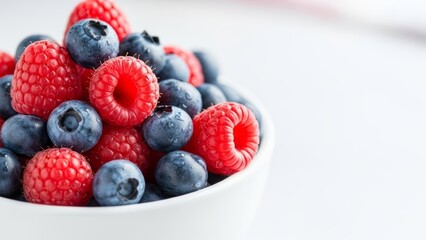 Enjoy fresh raspberries and blueberries in a bright bowl for a healthy breakfast or vibrant dessert