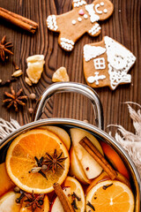 preparation of mulled wine in pot wooden background top view