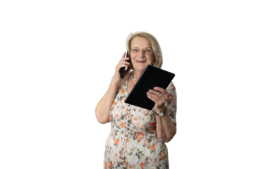 Happy senior woman multitasking with smartphone and tablet