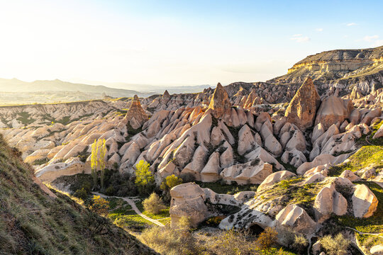 View of the surreal landscape of fairy chimneys, sculpted rock formations bathed in the warm glow of the setting sun, Cappadocia, Turkey, Goreme, Cappadocia, Turkey.