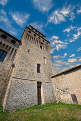 View from medieval fortress with stone walls and terracotta rooftops blending into the peaceful rural landscape of Italy.