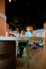 Businesswomen engage in conversation at a contemporary workspace during a casual meeting while enjoying beverages