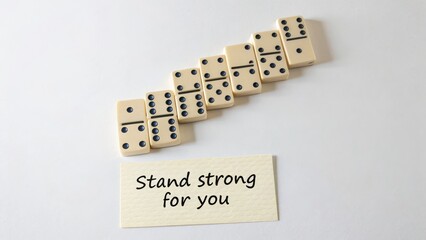 Dominoes standing with message of support on white surface