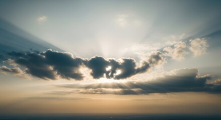 Dramatic sun rays piercing through dark clouds at sunset