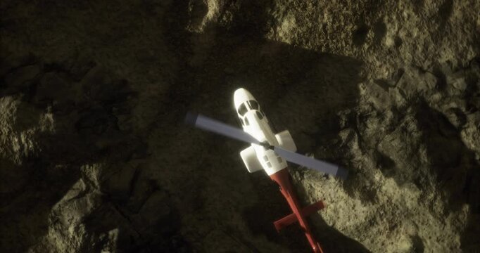 A helicopter hovers above a rugged cliffside, capturing the surrounding wilderness in bright daylight. The scene showcases natural textures of rocks and shadows cast by the chopper.