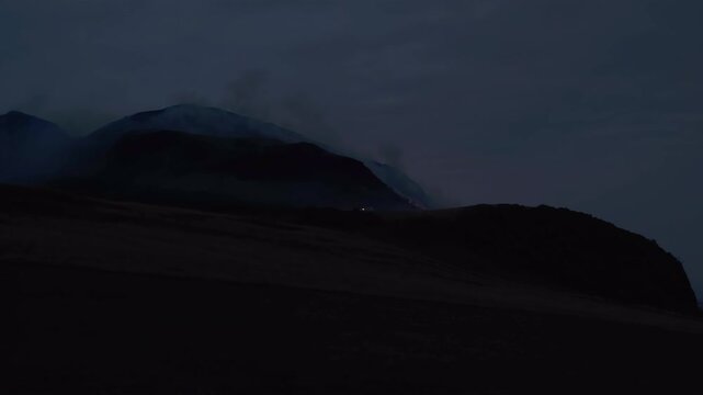 EDINBURGH, SCOTLAND, UK - AUGUST 10, 2025: Fire is visible on Arthur's Seat in Edinburgh during the evening hours, smoke is rising from the hill.
