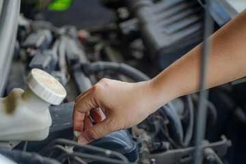 Close up of a hand of woman is checking a liquid coolant pot