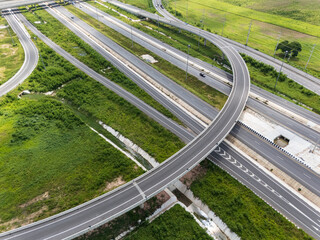 Drone shot a large highway interchange crossing over green farmlands in Thailand