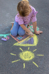 Fototapeta premium Children drawing with chalk on the asphalt. Selective focus.