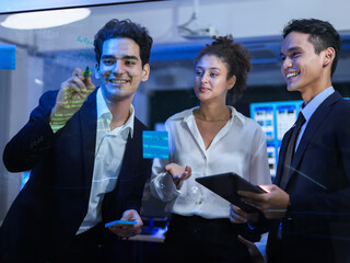 Diverse business professionals executives, collaborating on strategy. Brainstorming, writing on a transparent glass board. Using digital tablets for successful, corporate development and innovation