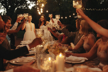 Celebration at an intimate garden wedding with guests toasting under outdoor lights