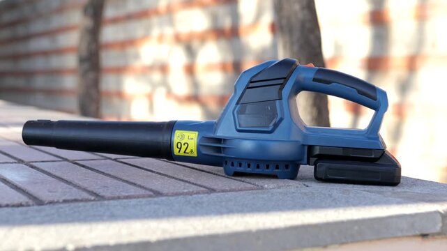 Side view of cordless leaf blower resting still on outdoor table