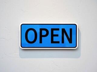 Bright blue open sign on a plain wall