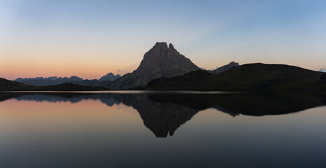 Mountain peak reflected in a calm lake at twilight with a gradient sky in the background view scene
