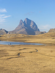 Picturesque landscape featuring a mountain range a lake and a field under a clear blue sky view