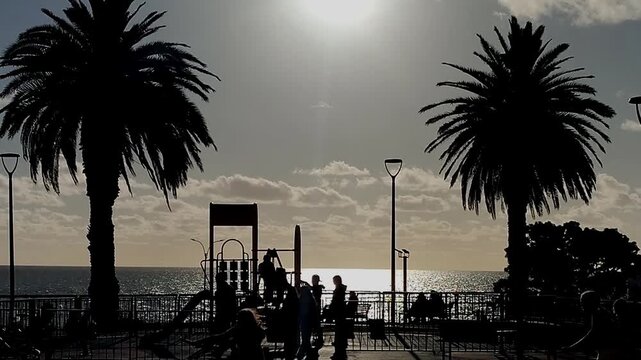 Children and families at waterfront urban park at sunset time in barrio sur neighborhood, montevideo city, uruguay