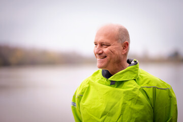 Close-up of a confident senior man standing outdoor in an autumn day