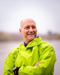 Close-up of a confident senior man standing outdoor in an autumn day