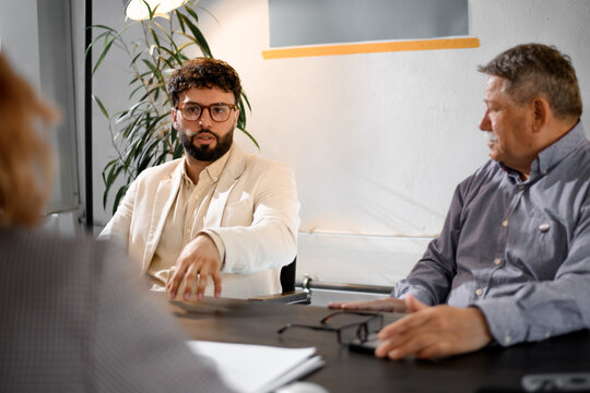 Business meeting in a modern office with two professionals discussing strategies and plans in a collaborative setting during the afternoon