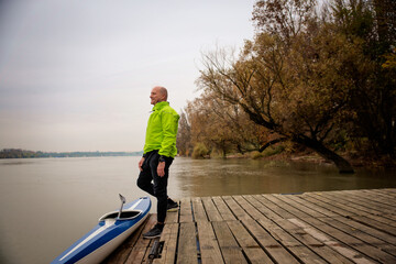 Confident senior man standing outdoor in an autumn day