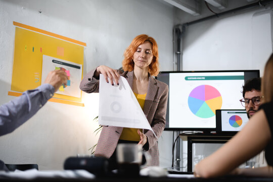 Business meeting with professional presenting data projected on screen, engaged participants in a modern office environment