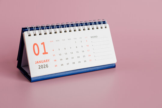 Desk calendar displays January 2026, featuring squares for each date. Design includes memo section for jotting down important notes. Background is light pink.
