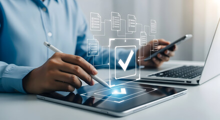 Person using a digital tablet and stylus for document management and approval workflow automation with a laptop and smartphone nearby in a modern office setting showcasing efficiency and technology
