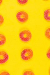 Jelly sweets rings on yellow background. Pattern.