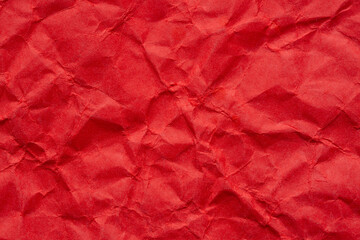 Fototapeta premium Close-up macro of wrinkled red paper texture,Red crumpled paper texture macro,Red crumpled paper as a texture or background. Bright red crumpled paper for backgrounds, design, packaging, 