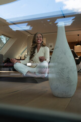 Happy senior woman practices yoga and meditates in relaxing pose, experiencing inner peace and mindfulness from the routine. Woman embracing the yoga lifestyle to achieve health and wellness.