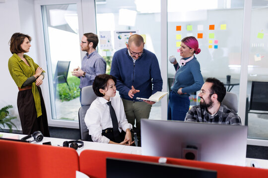 Collaboration among business professionals in a modern office setting during a brainstorming session to enhance productivity and teamwork